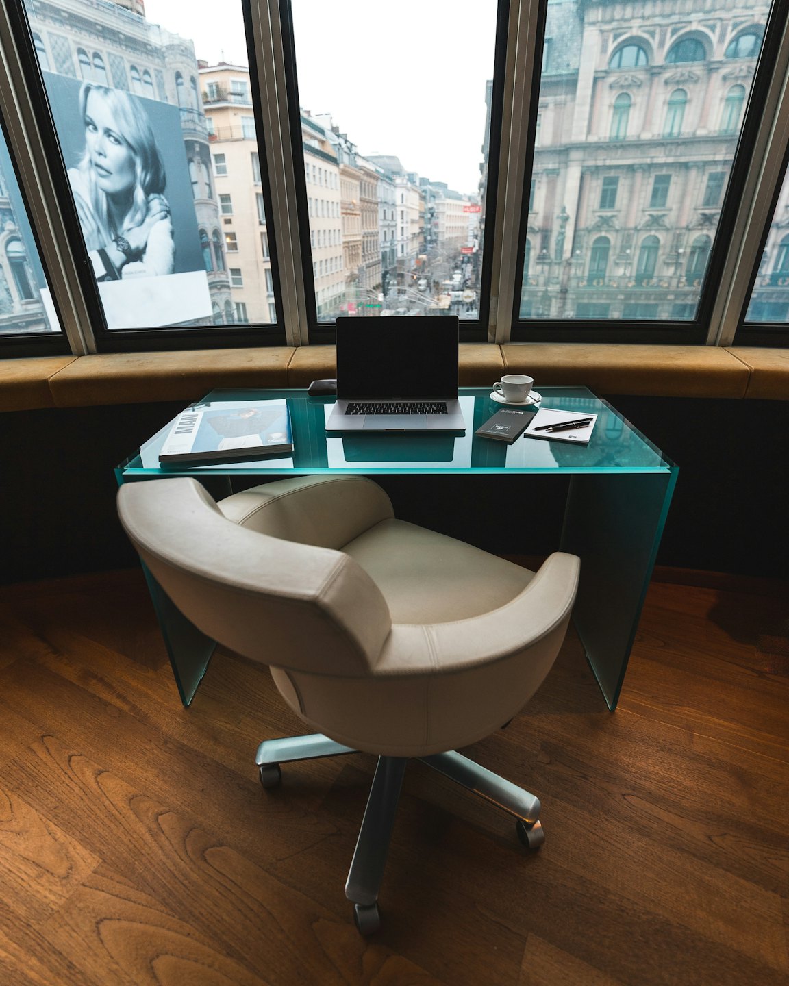 Modern office desk and chair overlooking European city street.