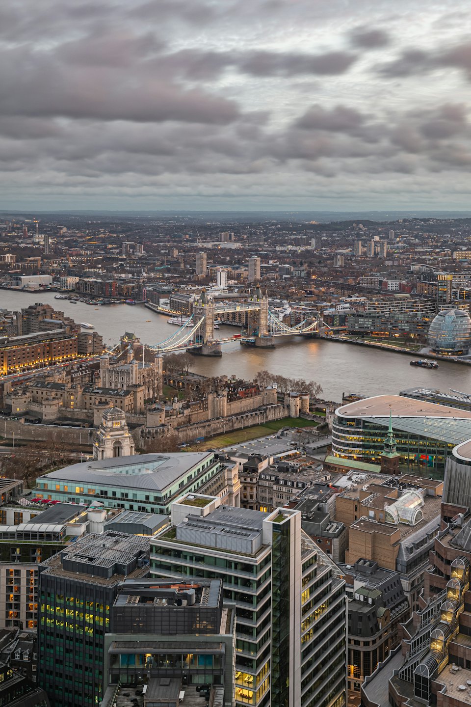 Aerial view of London cityscape with Tower Bridge at dusk.
